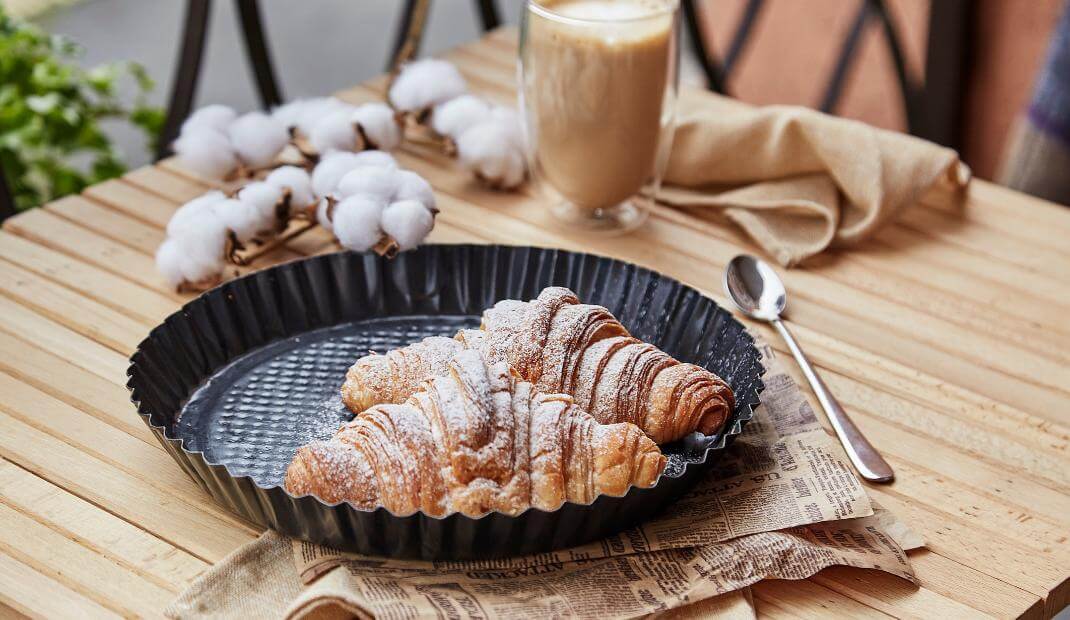 Desayuno de café con leche con croissant