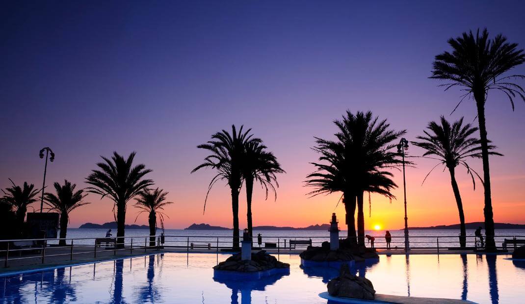 Paisaje de Samil con palmeras y el atardecer de fondo